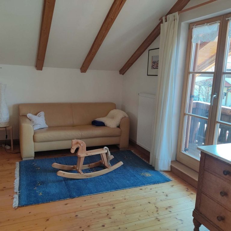 Wohnraum mit Sofa und Schaukelpferd